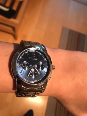 Blå klocka - Stilren klocka från FNGEEN med metallarmband i silver och blå urtavla. Klockan har romerska siffror, tre mindre urtavlor och en klassisk rund form. Perfekt accessoar för dig som gillar en elegant och modern look.