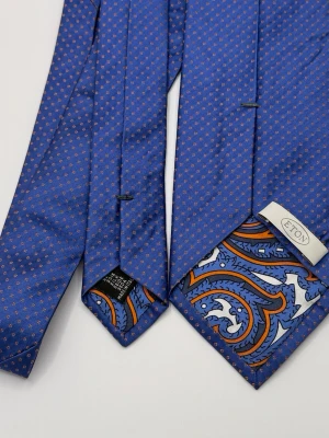 Blå slips med paisley från Eton - Blå slips i siden från Eton med små orange prickar och en snygg paisleydetalj på baksidan. Slipsen har klassisk spetsig form och känns riktigt exklusiv tack vare materialet och de unika mönstren. Perfekt för dig som vill sticka ut lite extra.