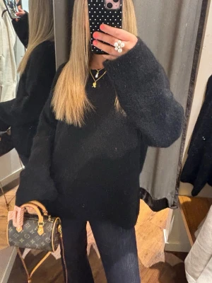 Oversized svart stickad tröja - Säljer en oversized svart stickad tröja med lång ärm och avslappnad passform. Den är i ull vilket gör den jättefin i materialet, lite fluffig. Som ny!!
