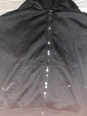 Svart zip hoodie med huva - En klassisk svart hoodie med dragkedja framtill och stor ficka på magen. Hoodien har en rymlig huva och ribbade muddar vid ärmar och nederkant. Perfekt för en avslappnad och stilren look.