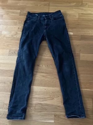 Mörkblå slim fit jeans - Snygga mörkblå calvin Klein slim fit jeans med klassisk femficksdesign och bälteshällor. Jeansen har en knappgylf och raka ben. Perfekta för dig som gillar en enkel och stilren look.