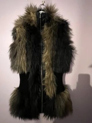 Svartbrun fuskpälsväst med dragkedja - Säljer en fluffig svartbrun pälsväs. I topp skick :)