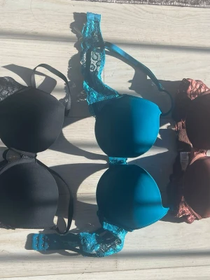 3-pack push up bhar spetsdetaljer - Säljer ett 3-pack bhar i storlek 75b iolika färger: svart, petrolblå och rostbrun. Alla bhar har vadderade kupor och fina spetsdetaljer på banden och runt om. Justerbara axelband och hakknäppning bak.