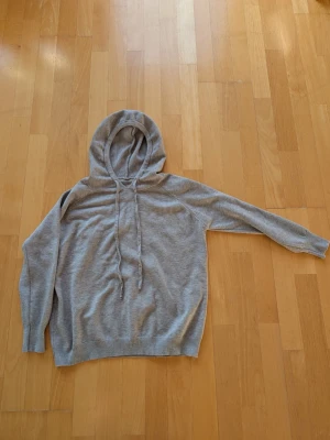 Ljusgrå merino ull hoodie - En otroligt fin och stilren merino ull hoodie. Tröjan är storlek S men passar XS.