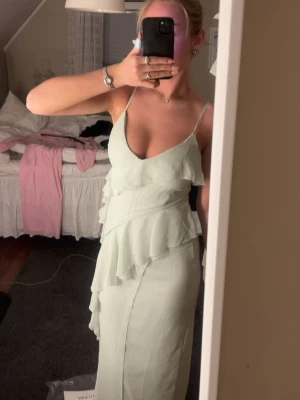 Ljusgrön långklänning med volanger - Från Gina Tricot, Storlek 38, men liten i storlek så mer som en 36. använd 1 gång 