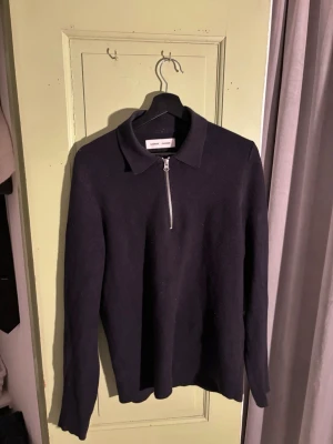 Samsoe Samsoe halfzip  - Snygg svart stickad tröja från Samsøe Samsøe med krage och halv dragkedja framtill. Tröjan har lång ärm och en klassisk, stilren look som passar till många outfits. Perfekt för dig som gillar minimalistisk stil.