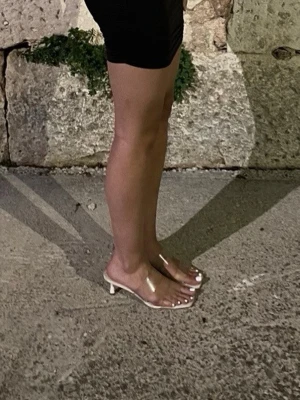 Vita slip-in sandaler med klack - Stilrena vita slip-in sandaler från Stradivarius med transparenta remmar och låg klack. Sandalerna har fyrkantig tå och en modern, minimalistisk look. 