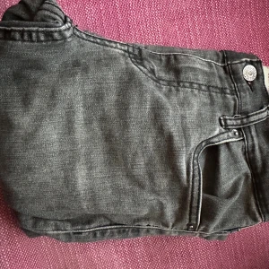 Levi's 512 Slim Taper svarta jeans - Säljer ett par svarta Levi's 512 Slim Taper jeans med en klassisk grå färg och knappdetaljer i midjan. Jeansen har en smal passform som smalnar av nedtill och är perfekta för en clean och modern look. Materialet är mjukt denim med lätt tvättad effekt. Skicket är fantastiskt och jeansen är sjukt sköna. Priset kan diskuteras.