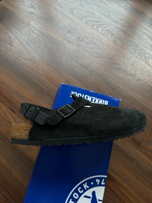 Svarta Birkenstock tofflor i mocka - Säljer ett par Birkenstock Boston i svart mocka, strl 38 helt nya och aldrig använda. Originalbox medföljer. 