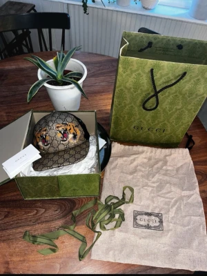 Gucci keps med tigertryck och GG-mönster - Säljer nu denna fina Gucci keps pga av att den inte kommer till intresse, alla kepsens tillbehör följer med samt box och kvitto. Pris kan diskuteras vid snabb affär.