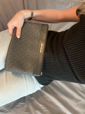 Svart kuvertväska från Michael Kors - Snygg svart kuvertväska från Michael Kors med några små defekter som inte syns 