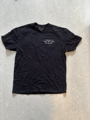 Svart t-shirt med tryck från Polar - Svart t-shirt från Polar med vitt texttryck på bröstet och ett större grafiskt tryck på ryggen. Klassisk passform med rund hals och korta ärmar. Tillverkad i mjuk bomull, perfekt för en avslappnad streetwear-look.