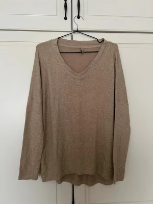 Beige v-ringad tröja i bomull - Enkel och stilren beige tröja med v-ringning och långa ärmar. Tillverkad i mjuk bomullsmix som känns skön mot huden. Passar perfekt till lager på lager och har en avslappnad passform. Oversixed 
