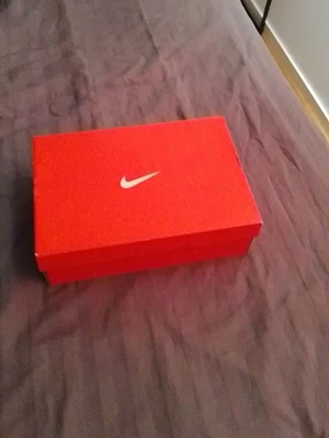 Nike sneakers i röd originalkartong obs endas kartong - Säljer ett par Nike sneakers i original röd kartong med klassisk vit swoosh-logga. Skorna levereras i Nike-låda, perfekt för dig som gillar stilrena och sportiga skor från ett av världens mest kända märken.