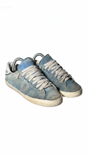 Blå Philippe Model sneakers i mocka - Snygga blå sneakers från Philippe Model med ovandel i mocka och detaljer i vitt. Skorna har vita snören, lågt skaft och en klassisk siluett. Perfekta för dig som gillar en stilren och trendig look.