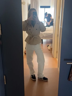 Vita raka jeans från Gina Tricot - Säljer ett par vita jeans från Gina Tricot med rak passform och klassisk femficksdesign. Jeansen har låg midja och är tillverkade i ett kraftigt bomullstyg. Perfekta för en clean och fräsch look året runt.