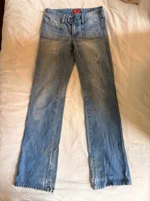 Ljusblå raka jeans från Miss Yes! - Säljer ett par ljusblå jeans från Miss Yes! med raka ben och slitna detaljer på låren och knäna. Klassisk femficksmodell i denim med normal midja och dragkedja. Perfekta för en avslappnad och trendig look.