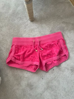 Rosa vintage shorts med snörning - Snygga rosa shorts med snörning i midjan och ribbade kanter. Shortsen har ett subtilt mönster i tyget och är perfekta för varma dagar. De har en sportig vibe och är riktigt bekväma att ha på sig. Det står M men skulle säga att de passar mer som L💕 