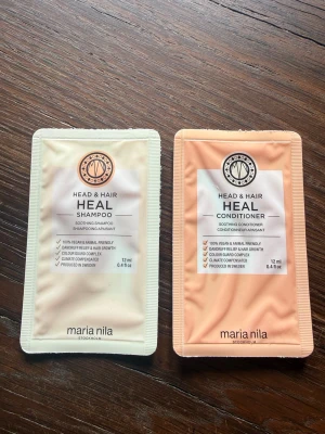 Maria Nila Head & Hair Heal duo Shampoo & Balsam  - Testkit med Maria Nila Head & Hair Heal schampo och balsam i små förpackningar om 12 ml vardera. Schampot är ljusbeige och balsamet ljusorange, båda veganska och klimatkompenserade. Perfekt för dig som vill prova produkter som stärker hår och hårbotten.