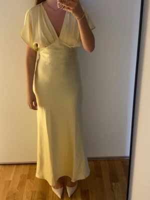 Ljusgul långklänning i satin - Hej! Säljer denna  populära klänning som är slutsåld  i storlek 34 passar även för storlek 36💗Den jag har är helt ny med prislapp kvar!