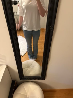 Ljusblå bootcut jeans - Säljer ett par ljusblå bootcut jeans med lågmidja. Jeansen är från Nelly och är i storlek 34. Dom är väldigt stretchiga och har fina rosa sömmar på fickorna💗
