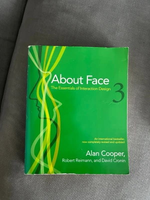 About Face 3 av Alan Cooper - Säljer boken 'About Face 3: The Essentials of Interaction Design' av Alan Cooper, Robert Reimann och David Cronin. Omslaget är grönt med grafiska linjer i gult och grönt samt vita och svarta detaljer. Perfekt för dig som är intresserad av interaktionsdesign.
