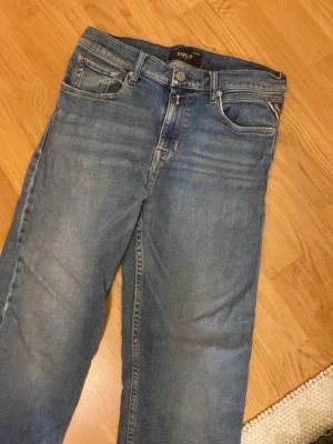 Blå raka jeans från Replay - Säljer ett par klassiska blå jeans från Replay med rak passform och fem fickor. Jeansen har en snygg tvättad look och är tillverkade i mjukt denimtyg. Perfekta för en avslappnad stil och passar till det mesta.