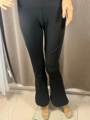 Svarta utsvängda leggings - Snygga svarta leggings med utsvängda ben och hög midja. Stretchigt material som sitter skönt och följsamt. Perfekta för en trendig och avslappnad stil.