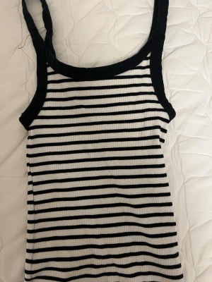 Randigt linne - Super gulligt linne med svarta och vita ränder på. Ribbstickat och ganska stretchiga material. Säljer då jag inte riktigt använder det. Pris kan absolut diskuteras och skriv gärna ifall du har frågor! ❤️