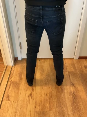 Dondup jeans  - Säljer ett par mörkblå slim fit jeans med klassisk femficksdesign och normalhög midja. Jeansen har smal passform hela vägen ner och subtila slitningar för en modern look. Perfekta till sneakers eller boots.