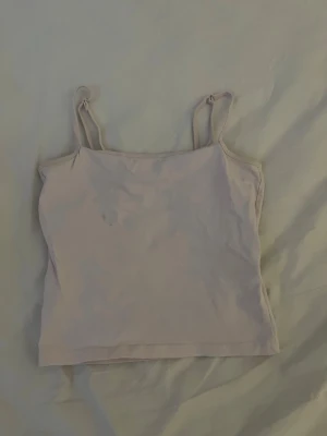 Ljusrosa linne - Säljer en enkel och stilren ljusrosa linnetopp från 157 med smala axelband. Toppen är gjord i mjuk bomull med lite elastan för extra stretch och komfort. Perfekt att matcha med jeans eller kjol för en clean look. Mycket bra skick förutom en liten fläck på framsidan💕