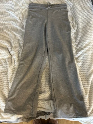 Grå mjukisbyxor  - Säljer ett par grå mjukisbyxor med utsvängda ben. Perfekta för chill dagar eller när du vill vara extra bekväm. Byxorna har en enkel och clean look utan synliga loggor eller detaljer. Knappt använda, pris kan diskuteras!❣️