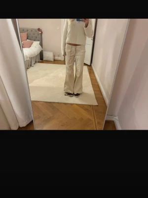 Vida beige manchesterbyxor - Säljer ett par vida jeans i beige med låg midja och fickor framtill. Byxorna har en avslappnad passform och är perfekta för en trendig och chill look. 