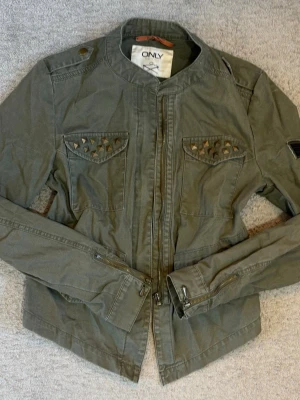 ONLY militärjacka med nitar & patches S  - Snygg militärinspirerad jacka från ONLY i olivgrön färg. Detaljer med nitar på bröstfickorna och patches på ärmen. Mycket fint skick💕💕