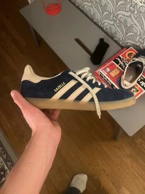 Adidas gazelle indigo (oanvända) - Marinblå skor från Adidas med bytta snören till vita som är köpt på skoaffär. Ger dom en mycket snyggare look och ser sjukt feta ut. Marinblå OG snören följer me. Box och allt också. Färgen är svår att hitta billig i storlek 43.