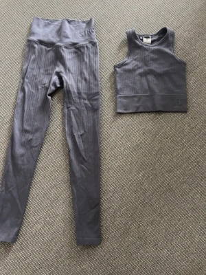 Träningsset  - Fint träningsset från Stronger i glansig grå. Perfekt till yoga/pilates/cardio. Köpt för 1000:- Båda delarna är i xs