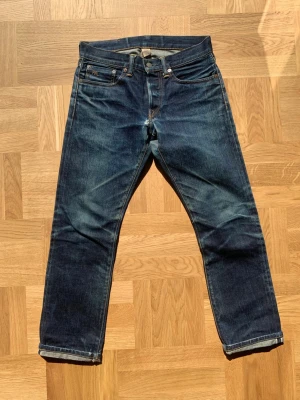 RRL Japanese selvedge jesns - Jeans från Ralph Lauren Double RL i japanskt selvedge tyg. Byxorna har utvecklat kraftiga fades så som tydliga honeycombs på baksidan från naturlig användning. Storlek w28 men utgå från måtten:  Ytterben: 92 Innerben: 70 Midja:39 Benöppning: 18  Skriv vid frågor eller funderingar! /william