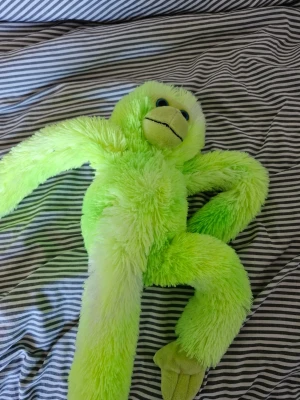 Grön mjuk apa gosedjur - Supermjuk och fluffig apa i neon-grönt plyschmaterial med långa armar och ben. Ansiktet är ljust med broderade detaljer och svarta ögon. Perfekt som kramkompis eller dekoration i rummet.