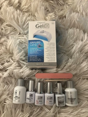Depend Gel iQ UV/LED nagellack kit ANVÄNT  - Depend Gel iQ kit med UV/LED-lampa, flera nagellacksflaskor i ljusa nyanser, cleanser, base coat, top coat och nagelfil. Perfekt för gelnaglar hemma med professionell finish. Flaskorna har silverfärgade lock och är tillverkade av plast. De är lite använt ca 3ggr så de är inte fulla förpackningar 