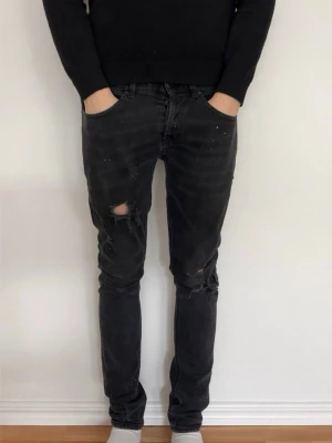 Svarta slitna skinny jeans - Säljer ett par Dondup jeans i modellen George//storleken är W31//jeansen är mycket unika med otroligt feta och sällsynta slitningar men även färgstänk//man ser hud på några ställen//färgen är mörkgrå//kontakta mig för fler bilder eller prisförslag!!