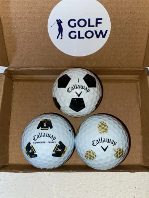 Callaway Chromesoft bollar 3-pack  - Tre vita Callaway golfbollar med olika tryck: en med svart fotbollsmönster, en med svarta och gula motiv samt en med guldiga ananaser. Perfekta för dig som vill sticka ut på golfbanan och ha lite roligare bollar i bagen.