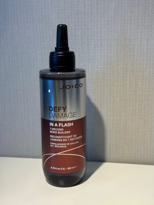 Joico Defy Damage In A Flash 200ml - Oöppnad! Joico Defy Damage In A Flash är en 7-sekunders bond builder för håret. Produkten kommer i en silver- och brunfärgad plastflaska med svart applikator. Perfekt för att stärka och skydda håret mot skador. Innehåller 200 ml.