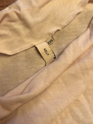 Ljusrosa offshoulder topp från Nelly - Trendig ljusrosa offshoulder topp från Nelly i mjukt material. Toppen har lång ärm och en tight passform som framhäver siluetten. Perfekt att styla med jeans eller kjol för en cool look.