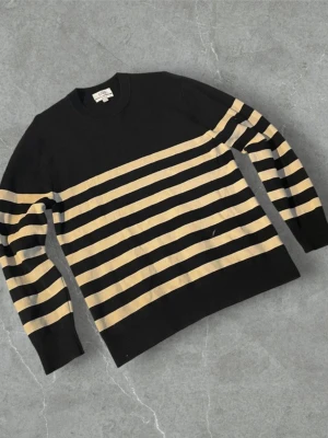 Randig svart-beige stickad tröja COS | M - Snygg stickad tröja från COS i svart med beigea horisontella ränder. Tröjan har rund halsringning och långa ärmar. Perfekt för dig som gillar enkel men stilren design. Regular fit och mjukt material.