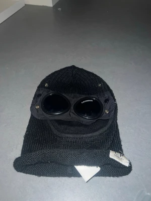 Svart C.P. Company balaclava - Äkta CP Company balaclava. Har gått sönder i kanterna och har bara sytts slarvigt