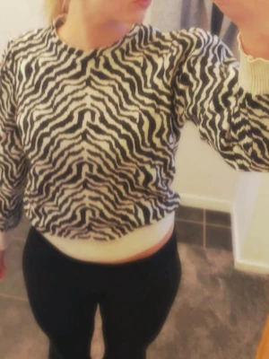 Zebra-stickad tröja - Säljer en beige och svart zebramönstrad stickad tröja från Pieces i storlek S. 🖤🤍 Tröjan har en mjuk och skön kvalitet med en snygg passform och är lätt puffig vid axlarna, vilket ger en fin och trendig siluett. Supersnygg och trendig!!  I toppskick utan några skavanker. Perfekt att styla både till vardags och lite mer uppklätt.  En riktigt trendig statement-tröja! Tveka inte på att ställa frågor 💕