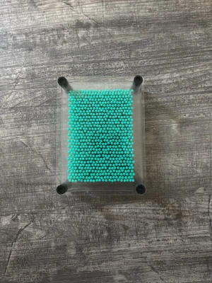 Turkos pin art leksak i plast - Rolig pin art leksak med turkosa plastpinnar och transparent ram. Skapa egna 3D-mönster genom att trycka olika former mot pinnarna. Perfekt som prydnad eller för att fördriva tiden. Lätt att använda och passar på skrivbordet.