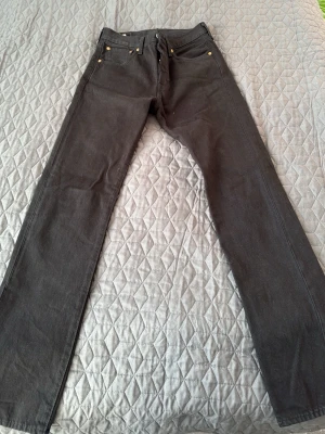 Svarta raka jeans från Levi's - Säljer ett par svarta jeans från Levi's med klassisk rak passform. -tagg på bakfickan. Perfekta till din vardagsstil.