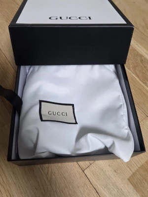 Svart bälte med guldspänne - Snyggt svart bälte  med spänne i guld. Bältet är gjort i skinn och levereras i originalförpackning med dustbag. Perfekt accessoar för att lyfta din outfit.