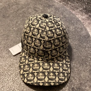 Salvatore Ferregamo Keps - Tja! Säljer en snygg keps ifrån Salvatore Ferregamo, helt ny, med tag på. Skriv vid minsta lilla fundering! :) 